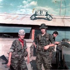 two soldiers are standing in front of a building with a sign that says chi lua on it