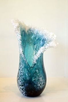 a blue vase sitting on top of a table