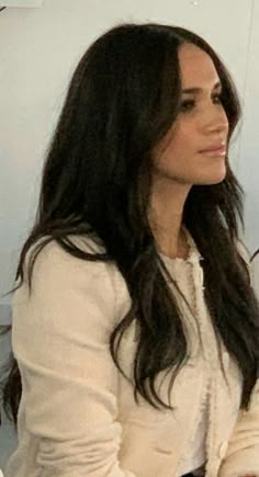 a woman with long black hair sitting down