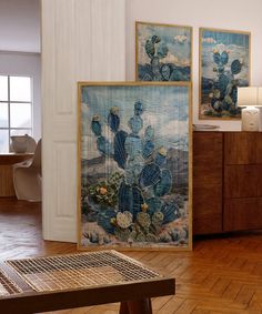 two paintings on the wall next to a wooden table