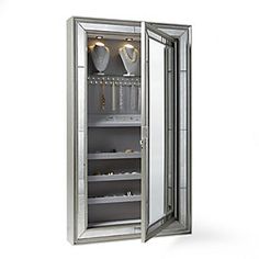 an open mirrored cabinet with wine glasses on the door and shelves below it, in front of a white background