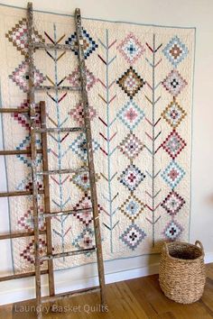 a ladder leaning against a wall next to a quilt