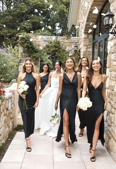 a group of women in black dresses standing next to each other on a stone walkway