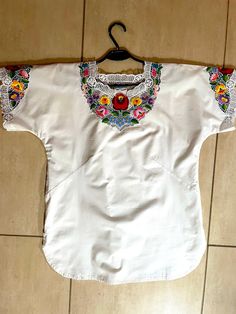 A Unique Handmade white blouse embroidered with authentic Hungarian Kalocsa pattern. A beautiful Hungarian Traditional Handmade Blouse. It was hand embroidered lately by  a unique Hungarian craftswoman. This Hungarian blouse is unique and only, because there is no two identical pieces of handwork. This blouse is an amazing embroidered outfit suitable for many occasions. It can be a gift for mom, sister, wife daughter or the loved ones. It can be a fall outfit for ladies both for a special occasi White Traditional Embroidered Top For Summer, Traditional White Embroidered Top For Summer, White Embroidered Blouse For Spring, White Machine Embroidered Blouse For Spring, Traditional White Cotton Blouse, Traditional White Top With Floral Embroidery, Traditional White Tops With Floral Embroidery, White Embroidered Top With Hem Detail For Festivals, White Embroidered Top With Border For Festival