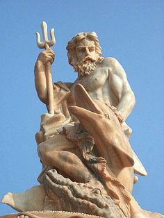 a statue with a hammer in his hand and a dolphin on the other side, against a blue sky