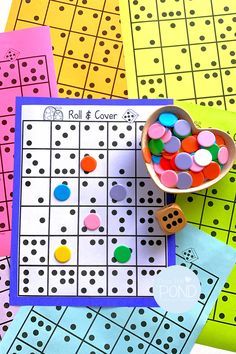 a game board with lots of different colors and shapes on it, next to some dices