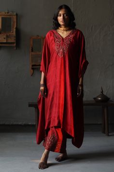 Ruby red kaftan with embroidery in a floral pattern and asymmetrical hem. Comes with co-ordinating farshi pants.
Component: 2
Pattern: Embroidery
Type Of Work: Beads
Neckline: V neck
Sleeve Type: Kaftan Sleeves
Fabric: Kaftan: Mulberry Silk and Farshi: Cotton Silk; Lining: Shantoon
Color: Red
Other Details: 
Asymmetrical hem
Note: The yellow kaftan worn by the other model is not for sale
Occasion: Puja - Aza Fashions Silk Co Ord Set, Kaftan And Pants, Shorshe Clothing, Kaftan With Pants, Yellow Kaftan, Red Kaftan, Kaftan Sleeves, V Neck Kaftan, Fashion 2025