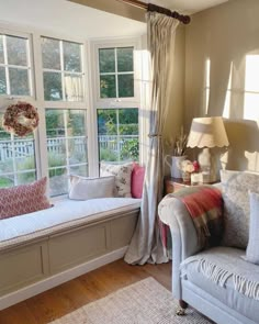 a living room filled with furniture next to a window covered in curtains and windowsills