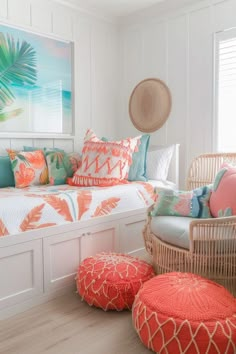 a white bedroom with orange and blue pillows on the bed, wicker chairs and rattan footstools