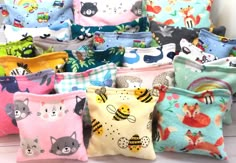 a bunch of small bags with animals and cats on them, all in different colors