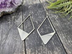 These geometric statement earrings feature 56mm x 27.5mm silver toned brass geometric diamonds. These minimalist geometric earrings will complement any outfit, and are lightweight enough for all day wear!The earrings measure approximately 2 7/8 inches from the bottom of the diamond to the top of the ear wires, which are made of hypoallergenic stainless steel, making them safe for sensitive ears. These earrings are very lightweight, each weighing 0.1 ounce. Domestic shipping is always free here a Geometric Metal Earrings With Ear Wire, Silver Triangle Jewelry With Ear Wire, Silver Triangle Single Earring, Geometric Metal Earrings For Everyday, Everyday Silver Triangle Earrings, Geometric Nickel-free Metal Earrings, Nickel-free Geometric Metal Earrings, Modern Silver Triangle Earrings, Modern Geometric Nickel-free Earrings