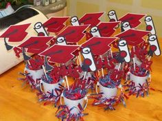 red and white graduation decorations in buckets on a wooden table with toaster oven