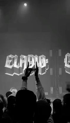 a person holding their hands up in front of a crowd at a concert with the words elapro on it