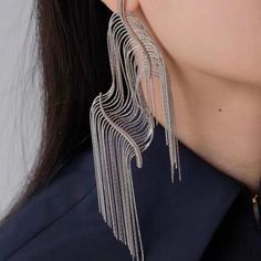 Introducing our Squiggly Line Silver Tassel Earrings – where art meets fashion for a bold and luxurious style statement! 🎨 **Artistic Innovation** 🎨These earrings are more than jewelry; they're wearable masterpieces. Crafted with hyper-realistic squiggly lines and bold contours, they mimic the look of cut and flexible edges, creating a unique work of art. ✨ **Silver Elegance** ✨Rhodium plated. They combine durability with a captivating shine. The silver tassel fringe adds movement, making them Trendy Chandelier Earrings For Evening, Silver Trendy Tassel Earrings For Party, Trendy Silver Tassel Earrings For Party, Elegant Metal Tassel Earrings, Silver Tassel Earrings For Party, Elegant Metal Plug Earrings, Artistic Dangle Jewelry For Party, Artistic Dangle Party Jewelry, Metal Tassel Drop Earrings For Party