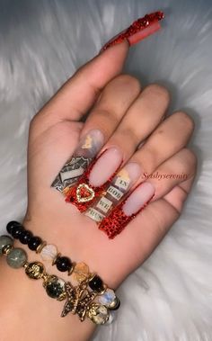 a woman's hand with red and gold nail polishes on it, including bracelets