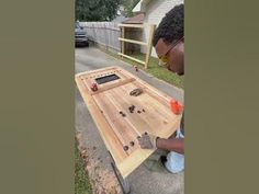 a man working on a wooden table outside