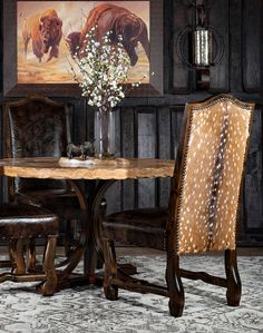 a table with two chairs and a vase filled with flowers