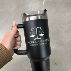 a person holding a black coffee cup with the words madison jones and an equal scale on it