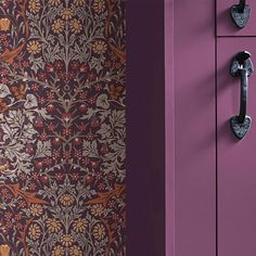 an ornate wallpaper design on the side of a purple cabinet