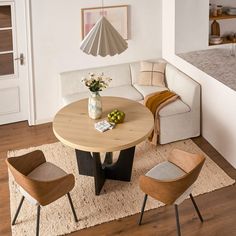 a living room filled with furniture and a white rug on top of a hard wood floor