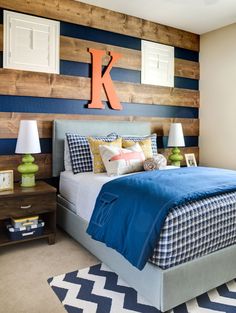 a bedroom decorated in blue and white with wood accenting the walls, along with two lamps on either side of the bed