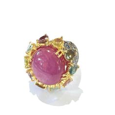 This is part of Chairish’s Fine Jewelry assortment.  Center Oval Shape Natural Ruby - 4 Carat  Multi color Natural Sapphires from Sri Lanka 2.50 Carat  Round and Pear shape Brilliant Colors: Pink, Yellow, Rose, Green and Blue   This Ring is from the "Orient" traveling collection are the epitome of elegance and versatility. It offers a perfect blend of day to night and swimwear to evening wear, allowing you to effortlessly transition between different occasions and outfits.  Wearing these spectac Multicolor Cabochon Rings In Fine Jewelry Style, Luxury Multicolor Cabochon Rings, Multicolor Cabochon Rings Fine Jewelry, Luxury Multi-stone Pink Sapphire Ring, Luxury Multi-stone Ruby Ring, Elegant Multicolor Ruby Ring, Luxury Pink Sapphire Ring With Gemstone Accents, Elegant Multicolor Cabochon Rings, Luxury Multi-stone Cluster Sapphire Ring