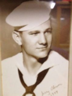 an old photo of a man wearing a sailor's hat with a tie around his neck