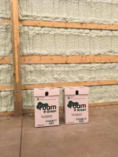 two white boxes sitting next to each other in front of a wall with foam on it