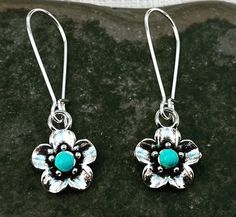 "Sweet and pretty little turquoise flower dangle earrings.  They are unique and versatile.  Dress them up or down.  The perfect everyday earrings. The flowers measure 1/2\" long 1/2\" wide.  They hang from kidney style ear wires that latch and lock.  Overall drop length is 1 1/2\". Made from plated silver. I have this same earring style also available with a red stone accent.  Here is a direct link https://www.etsy.com/listing/1387351493/ Thanks for stopping by!  Please take a moment and visit t Turquoise Nickel Free Flower Earrings, Nickel Free Turquoise Flower Earrings, Turquoise Dangle Flower Earrings, Turquoise Dangle Earrings With Flower Charm, Turquoise Teardrop Flower Earrings For Gift, Turquoise Earrings With Flower Charm As Gift, Turquoise Flower-shaped Earrings With Flower Charm, Turquoise Dangle Flower Earrings With Ear Wire, Turquoise Earrings With Flower Charm