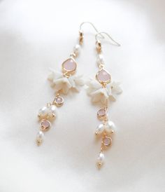 Be the belle of the ball with our SARINA earrings. Handcrafted in a long, intricate floral design, bejeweled with luscious freshwater pearls and pink opal stones, these earrings will make you sparkle like no other. With a sophisticated and artful design, you'll be chic and elegant on your special day. - Handcrafted in my studio in PA- Freshwater pearls- Polymer clay flowers- Yellow gold finish is pictured. Available in yellow gold or rhodium (silver)- Earrings measure 3.25 inches- Handcrafted in Bridal Long Earrings, Romantic Coquette, Long Bridal Earrings, Earrings With Pearls, Earrings Aesthetic, Pink Pearls, Flowers Yellow, Polymer Clay Flowers, Chic And Elegant