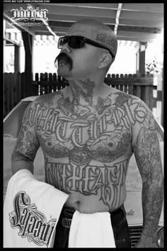 a man with tattoos on his chest holding a towel