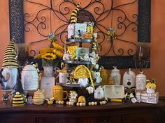 a table topped with lots of vases filled with yellow and white flowers next to a wall