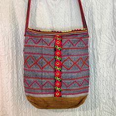 One of a kind bohemian bucket bag, handcrafted from a variety of vintage Hmong textiles. This gorgeous bag was lovingly made with vintage examples of indigo batik work, embroidery, applique, hemp, shells, beads, and tassels. All these diverse crafts brought together in a cohesive bohemian aesthetic. Lined in strong cotton, with 2 zippered interior pockets, this bag is perfect for wearing around town and whilst traveling! Bag body approximately 15" x 16" x 4" Fully lined with 2 zippered pockets inside. *please note, as with all handmade things, there will be slight variations reflecting the human who made it. We believe these "imperfections" are what make handmade things beautifully unique* The crafts of the Hmong people, amongst other Hill Tribes, are quickly becoming lost to cheap fast fa Bohemian Pouch Shoulder Bag With Hand-stitched Details, Bohemian Rectangular Bucket Bag For Daily Use, Traditional Bucket Bag With Adjustable Strap For Everyday, Bohemian Rectangular Bucket Bag With Adjustable Strap, Bohemian Tote Bucket Bag For Daily Use, Artisan Bucket Shoulder Bag For Daily Use, Bohemian Handwoven Satchel Bag, Bohemian Woven Bags For Daily Use, Embroidered Tote Bucket Bag For Everyday Use