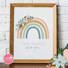 a wooden frame with an image of a rainbow and the words, the magic is in you