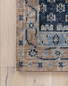 a blue and beige rug on top of a wooden floor