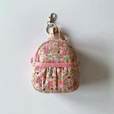 Floral mini cute backpack keychain, keychain pouch, keyring coin purse, earphone case, airpod case, earbud pouch, lipstick pouch (pink) Handmade in the UK Size:  - approximately 8cm (L) x 9cm (H) with 4cm base Material:  - 100% cotton (both outer and inner layer) - YKK zipper closure Notes:  - The position of pattern prints may slightly vary due to the different batches of the fabric - The actual color may slightly vary due to lighting effects and monitor settings Pink Coin Purse For Mobile Phone For Everyday Use, Pink Coin Purse With Cell Phone Pocket, Pink Coin Purse Mobile Phone Bag As Gift, Pink Coin Purse For Mobile Phone As Gift, Pink Coin Purse With Mobile Phone Bag For Gift, Pink Pouch With Cell Phone Pocket For Personal Use, Pink Pouch With Cell Phone Pocket, Pink Coin Purse With Cell Phone Pocket For Travel, Cute Pink Bag Charm For Everyday Use