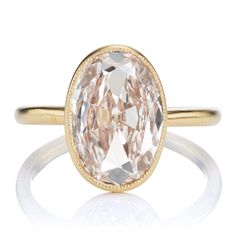 a ring with an oval shaped pink diamond in the center and two tone gold band