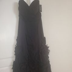 a black dress hanging up against a wall