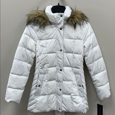 You'll Be So Bundled Up (And Chic) In This Ultra-Warm Puffer Coat By Tommy Hilfiger. Styled In That Perfect In-Between Length, It's Finished With A Luxe & Cozy Faux-Fur Trim. Funnel-Neck Collar With Removable Hood And Attached Faux-Fur Trim; Front Zipper Closure With Button Overlay Imported Lined Silver-Tone Hardware Snap Side Pockets Water Resistant Size & Fit Approx. Length: 29" From Center Back To Hem Winter White Outerwear With Adjustable Hood, White Winter Outerwear With Adjustable Hood, Fitted White Hooded Jacket For Fall, Fitted White Hooded Winter Jacket, Fitted White Hooded Jacket For Winter, White Fitted Hooded Jacket For Winter, Hooded Winter White Outerwear With Faux Fur Lining, Fitted Parka With Faux Fur Trim For Cold Weather, Fitted Winter White Outerwear With Faux Fur Lining