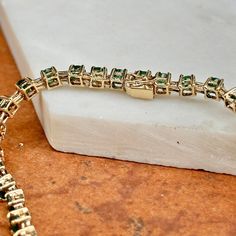 Estate/ vintage 18KT yellow gold polished, faceted, round, emerald tennis style bracelet with bar in center. High end, dark green emeralds look fabulous set in buttery 18k gold. Push in clasp with safety latch Weight: 8.9 DWT/ 4.2 Grams Measures 3.6mm wide Emeralds measure: 3mm Hallmarked but no longer stamped 18KT; Fully Tested 8" Length Can be shortened Bar in center plain, but could be engraved One emerald is slightly lighter in color (shown in photos, located on backside of bracelet.) Classic Emerald Cut Jubilee Bracelet, Luxury Yellow Gold Emerald Cut Bracelet, Elegant Green Jewelry With Box Chain, Classic Gold Emerald Cut Tennis Bracelet, Yellow Gold Emerald Cut Tennis Bracelet For Formal Occasions, Emerald Cut Yellow Gold Tennis Bracelet For Formal Occasions, Emerald Cut Yellow Gold Tennis Bracelet For Formal Events, Classic Emerald-cut Emerald Bracelet, Formal Yellow Gold Emerald Cut Tennis Bracelet