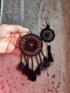 a hand holding a small black and white dream catcher