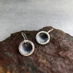 These silver earrings are made of two separate components, a fine silver (.999) textured domed disc and a sterling silver (.925) textured open circle. The domed disc is oxidised to contrast beautifully with the open circle which is not oxidised.  Handmade sterling silver earwires. Perfect for everyday wear. Diameter is approximately 1.7cm/ 0.66inch. I have 2 pairs available for the moment, so you may or may not receive the pair photographed. There may be small differences between the 2 pairs due