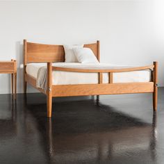 a wooden bed frame with two nightstands next to it