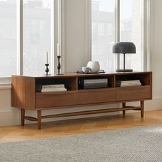 a living room scene with focus on the sideboard and lamp in the foreground