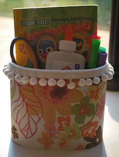 a close up of a cup on a table with books and toys in the background