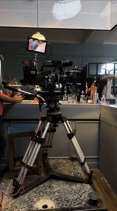 a man standing next to a camera on top of a tripod