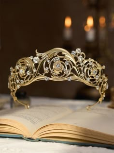 an open book with a tiara on top of it