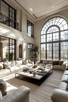 a large living room with white couches and windows