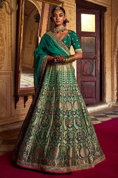 a woman in a green and gold bridal gown