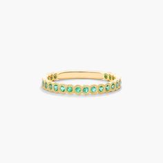 Crafted in 14K yellow gold, this contemporary band featuring bezel set round-cut emeralds with delicate milgrain detail is chic and timeless. Wear this brilliant band on its own or mix and match with other stackables for a fashion forward look. Elegant Emerald Ring With Bezel Setting, Elegant Emerald Ring With Smooth Bezel For Anniversary, Elegant Gold Emerald Ring With Smooth Bezel, Birthstone Wedding Band, May Birthstone, Types Of Gemstones, Engagement Bands, Matching Band, Engagement Ring Styles